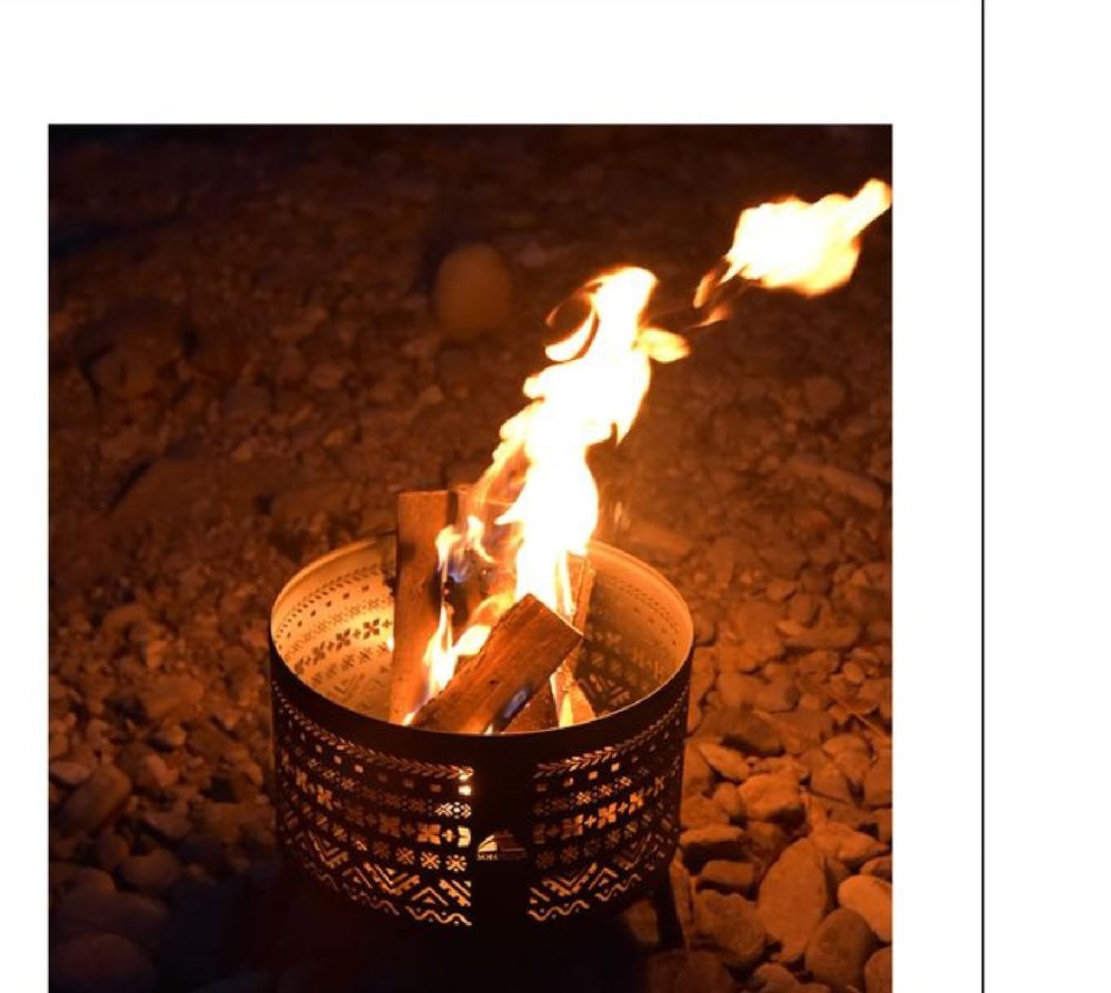 Steel fire pit burning at night